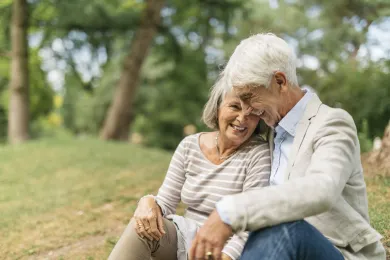 Ein älteres Ehepaar sitzt zusammen in Park