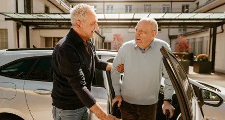Rotkreuz-Fahrer unterstützt den Fahrgast mit dem Rollator