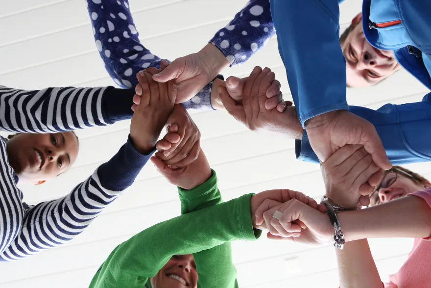 Vier Menschen geben sich die Hände